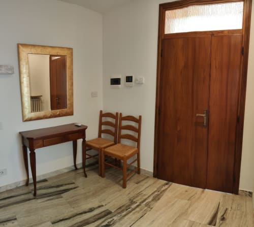 Apartment entryway at Villa Italia with wooden desk, chairs, mirror, and wardrobe doors, hardwood flooring