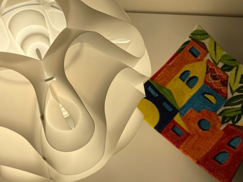 Lampada bianca moderna accanto a un cuscino decorativo colorato con motivo casa nell'Apartment GioviGemini a Treviso