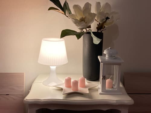 Elegante comodino nell'Apartment GioviGemini di Treviso con lampada, vaso di orchidea bianca e candele rosa