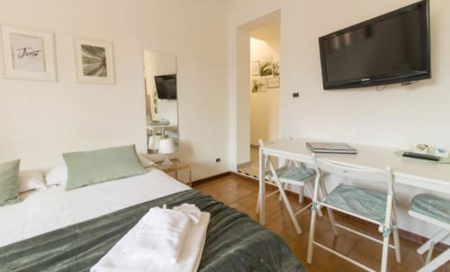 Camera moderna dell'Appartamenti Ferrara a Ferrara con letto, scrivania, TV e lettino pieghevole