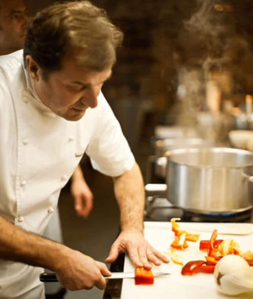 Chef préparant des légumes frais en cuisine à La Conciergerie du Cap Corse, Centuri