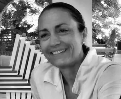 Gestionnaire immobilier souriant à La Conciergerie du Cap Corse à Centuri, cadre extérieur avec arbres