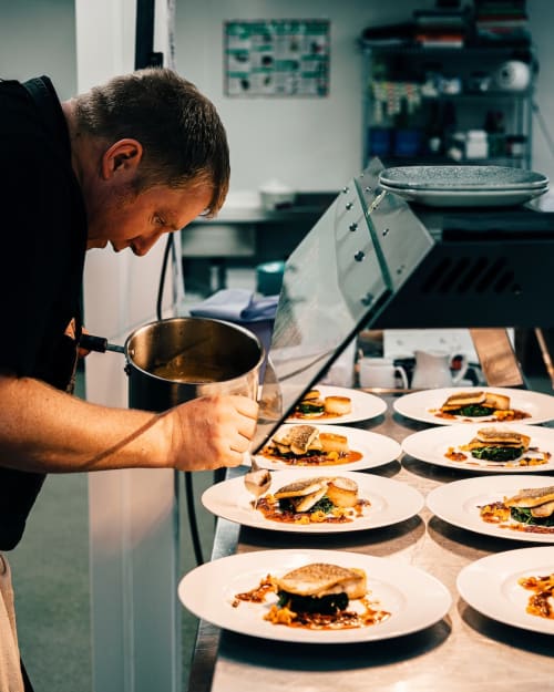 Chef plating gourmet dishes in Tulum kitchen at Your Private Concierge hotel