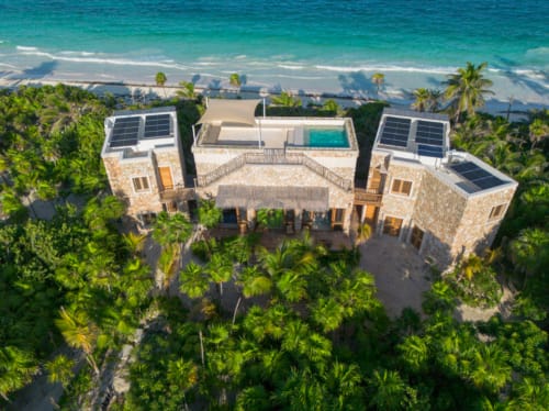 Vista aérea de la villa Kaab Kaan en Tulum con océano turquesa, paneles solares y jardines tropicales