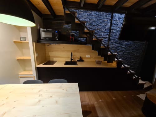 Cuisine moderne et coin repas de l'appartement Le Pralin à CMD Méribel avec comptoirs en bois, électroménagers noirs et vue montagne
