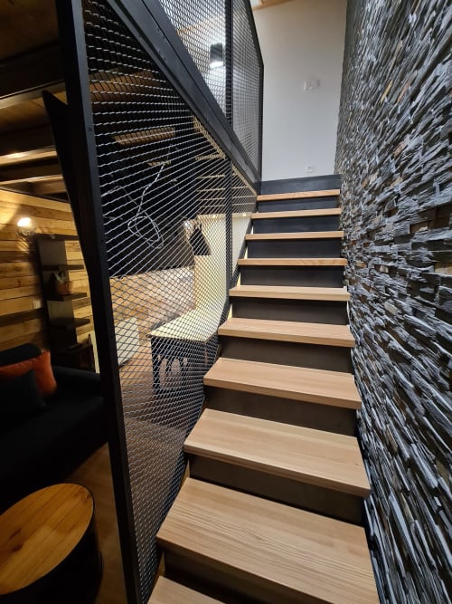 Escalier contemporain aux marches en bois et garde-corps en treillis métallique de l'appartement CMD Méribel Le Pralin aux Allues