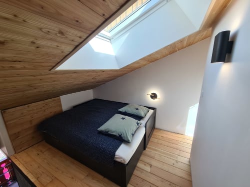 Chambre lumineuse sous les toits à CMD Méribel Le Pralin avec puits de lumière, poutres apparentes, lit queen-size et vue sur les montagnes