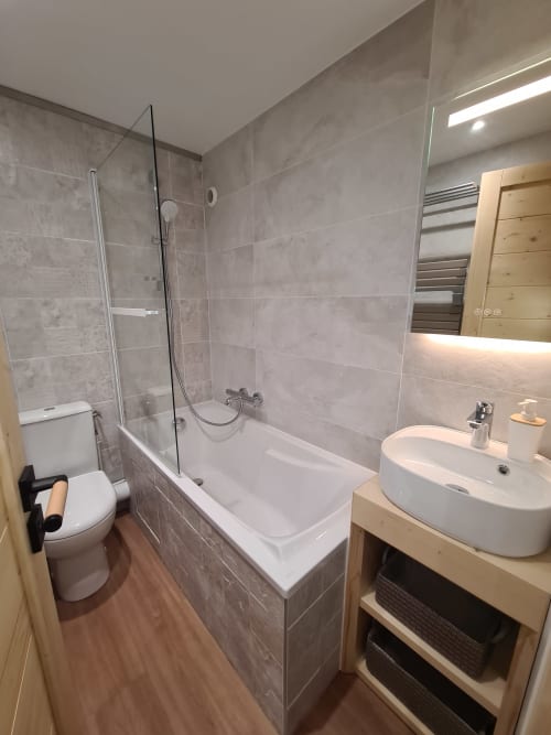 Salle de bains moderne avec baignoire, cabine de douche et lavabo rond à l'appartement CMD Méribel Le Pralin aux Allues