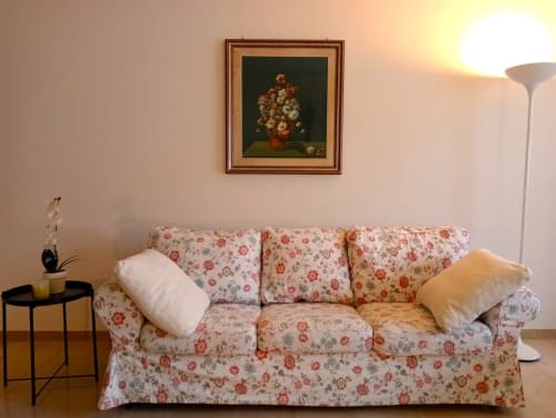Accogliente soggiorno a Treviso con divano floreale, quadri di nature morte e arredamento moderno