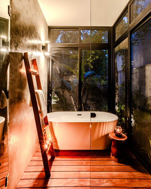 Baño exterior moderno en villa Karmond House, Tulum, con tina de inmersión iluminada, vistas al jardín e iluminación ambiental