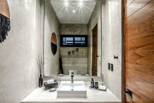Baño moderno en villa Karmond House, Tulum con vanidad de mármol, lavabo tipo recipiente y espejo decorativo