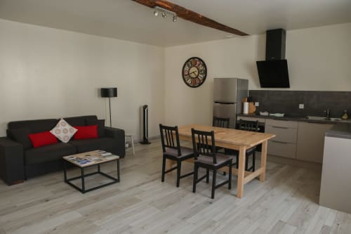 Appartement moderne à Chablis avec salon noir, table à manger en bois et cuisine équipée
