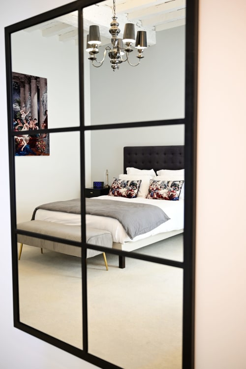 Elegant bedroom with black four-poster bed, mirrored door, and chandelier at Pavillon Des Millesimes in Lussac