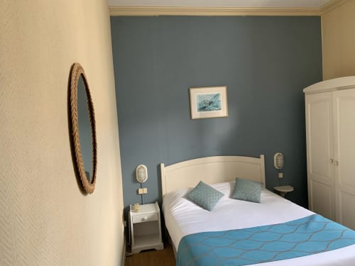 Cozy double bedroom at Hôtel Maison Richet with blue accent wall, white bed, and coastal decor in Les Sables-d'Olonne
