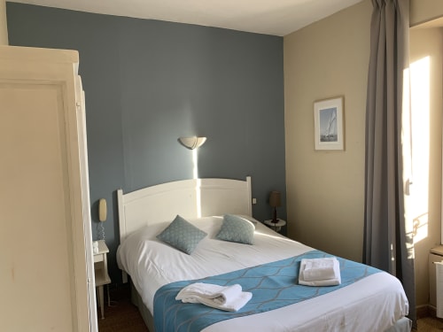 Bright double bedroom at Hôtel Maison Richet with white bed, grey accent wall, and seaside decor in Les Sables-d'Olonne