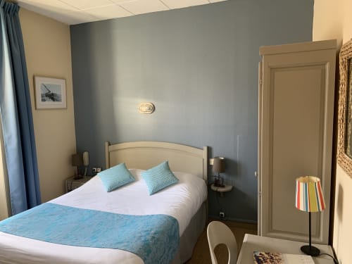 Modern double bedroom at Hôtel Maison Richet in Les Sables-d'Olonne with blue accent wall, queen bed, and work desk