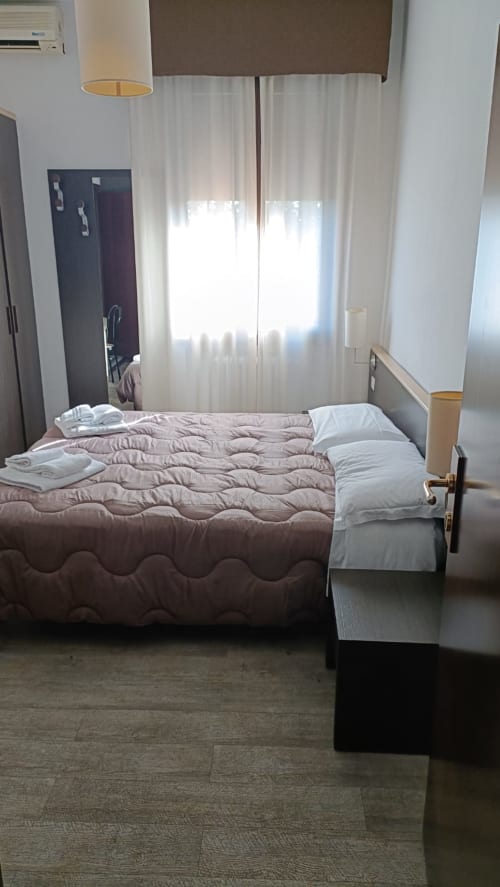 Camera moderna dell'Hotel Eden di Vignola con letto queen size, tende bianche e vista panoramica dalla finestra
