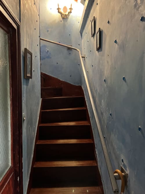 Escalier étroit aux marches en bois et rampe dans la chambre Rita de l'hôtel boutique Maison 1850 Paris Porte Montmartre