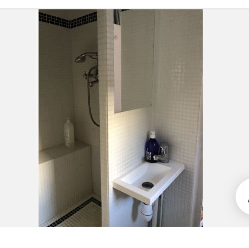 Salle de bain moderne dans la chambre de Gaspard à Maison 1850 Paris, avec carrelage blanc et accents de sol sombre