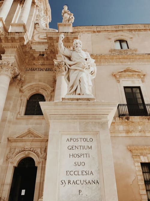 Statua in marmo di Santo e iscrizione latina sulla facciata della chiesa storica a Siracusa, Sicilia