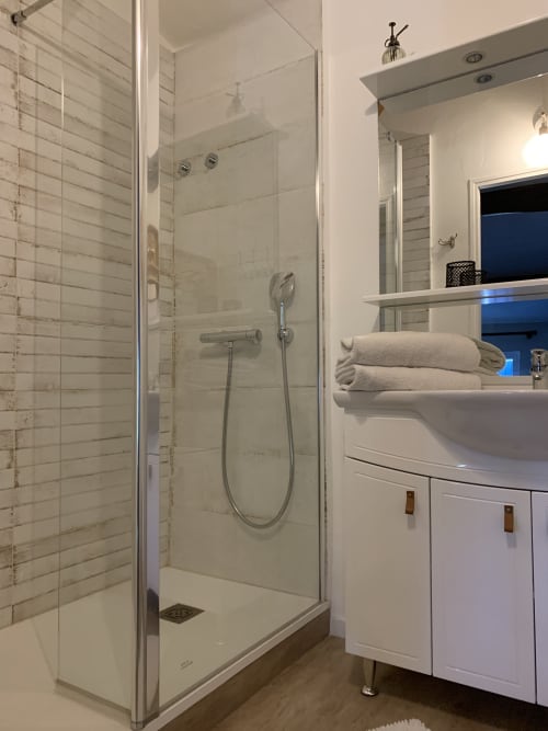 Salle de bain moderne avec douche à l'italienne, vasque blanche et serviettes pliées à la Maison d'Hôtes La Chabanaise en Marais Poitevin