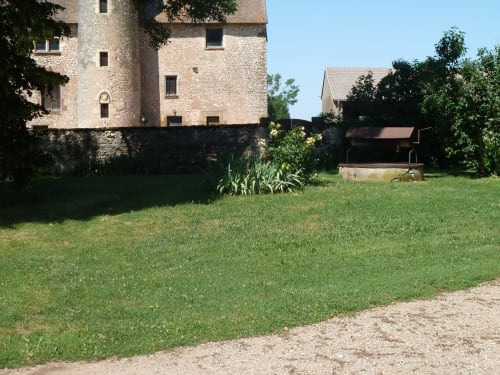 Castillo de piedra medieval con jardines cuidados en Château De Clusors BnB en St Menoux, Francia