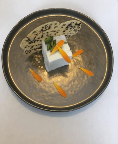 Artfully plated dish at Three Little Pigs hotel in Blandford Forum featuring white tofu, orange vegetable garnish, and