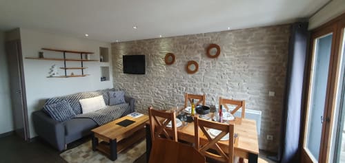 Séjour contemporain à la Résidence Le Pacha, Courchevel avec murs en pierre, canapé rayé, table à manger en bois