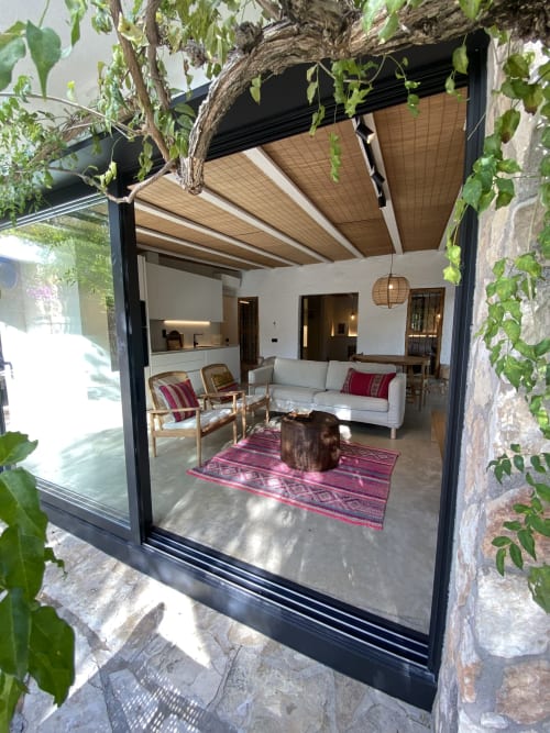 Espacioso salón abierto en BondBeach Village, Altafulla con puertas correderas de cristal, mobiliario costero y pérgola sombreada