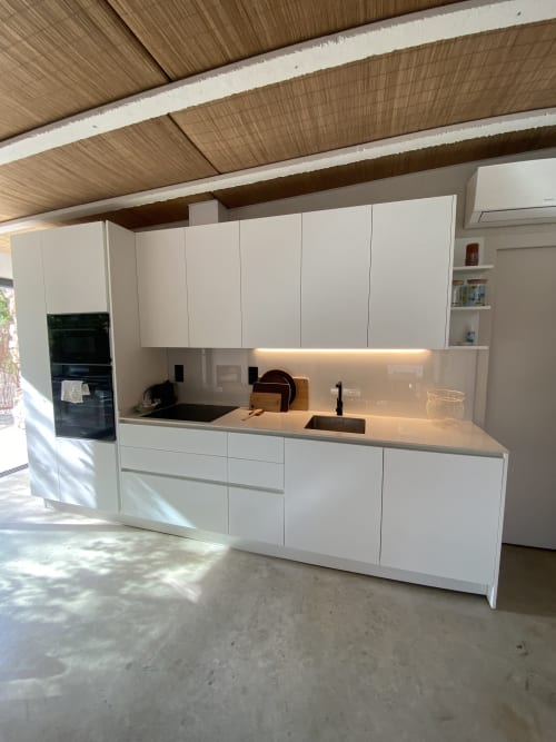 Moderna cocina blanca con vigas de madera en el techo en BondBeach Village, Altafulla