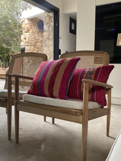 Silla lounge de mediados de siglo con respaldo de ratán y cojines a rayas burdeos en BondBeach Village, Altafulla