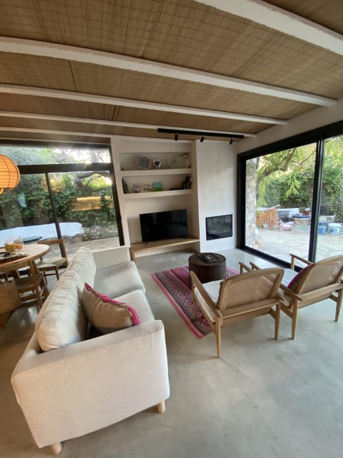 Sala moderna de BondBeach Village Altafulla con sofá color crema, sillas de madera y amplios ventanales con vistas al jardín