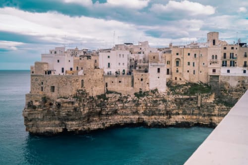 Polignano a Mare, affascinante borgo bianco arroccato su spettacolari falesie calcareniti vicino a Bari
