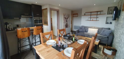 Salle à manger moderne avec table en bois, cuisine et canapé rayé à la Résidence Le Pacha, Courchevel