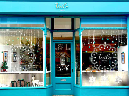 Twile Bakery storefront in West Kirby with bright turquoise facade, festive window displays, and holiday decorations