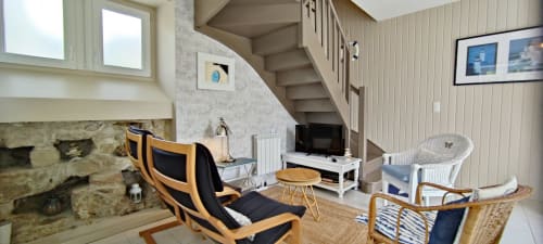 Salon moderne de villa à Mer et Maisons avec foyer en pierre, mobilier bois, télévision et escalier à La Trinité-sur-Mer