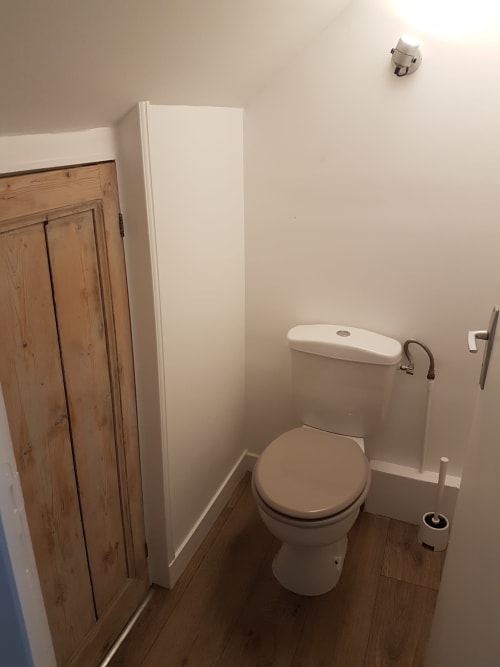 Salle de bains compacte de la Villa République Normandie avec toilettes, réservoir et meuble en bois à Caen