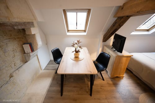 Chambre mansardée à la Villa République Normandie à Caen avec poutres apparentes, lucarnes, table à manger et mobilier contemporain