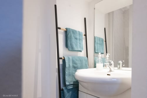 Salle de bains moderne à la Villa République Normandie B&B à Caen avec lavabo sur colonne, porte-serviettes noir et serviettes bleu-vert