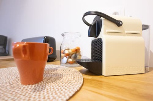 Machine à espresso crème avec tasse orange et capsules à Villa République Normandie, Caen