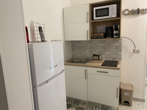 Piccola cucina attrezzata nell'appartamento Newhouse Bari con frigorifero bianco, microonde, lavello e piano di lavoro in legno