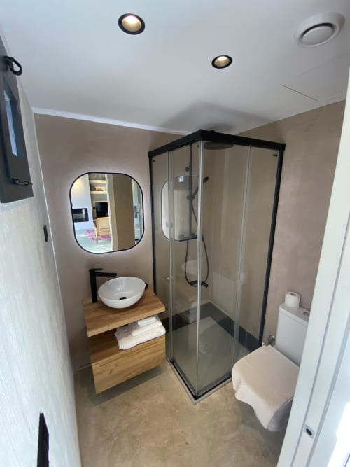 Baño moderno de villa en BondBeach Village con ducha, lavamanos de cerámica e espejo en Altafulla
