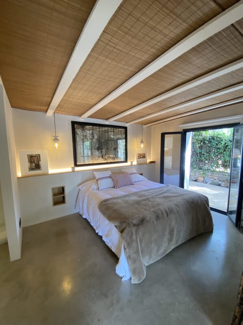 Dormitorio de villa moderna en BondBeach Village con cama queen, vigas de madera, lámparas colgantes y acceso a vista del jardín