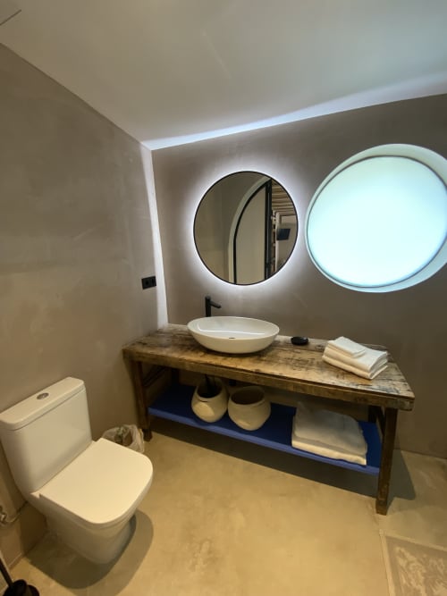 Baño moderno de la villa BondBeach Village con lavabo tipo vasija, espejos iluminados y tocador de madera