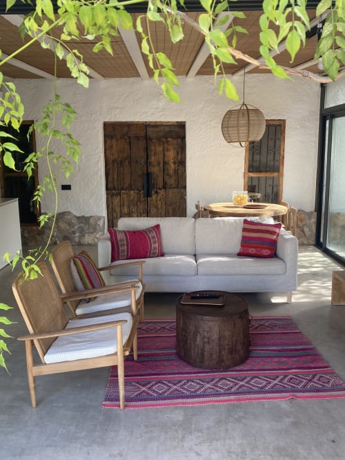 Terraza ajardinada elegante en villa BondBeach Village con zona de descanso, cojines decorativos y vegetación colgante en Altafulla
