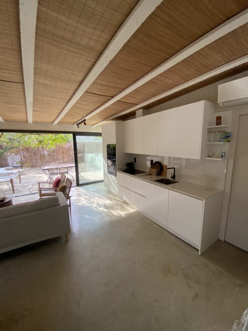 Cocina moderna blanca con vigas de madera en villa de BondBeach Village, Altafulla, con vistas al patio jardín