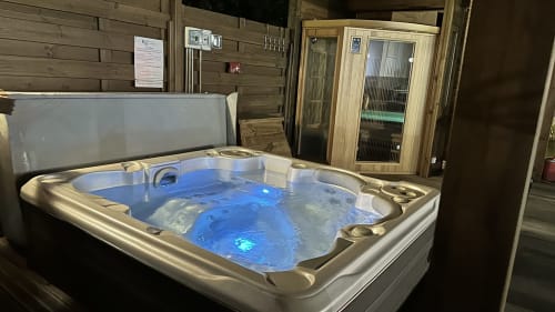 Bain à remous illuminé avec jets bleus à la maison d'hôtes Kaz A Bibi à Sainte-Rose, Guadeloupe, sauna en arrière-plan