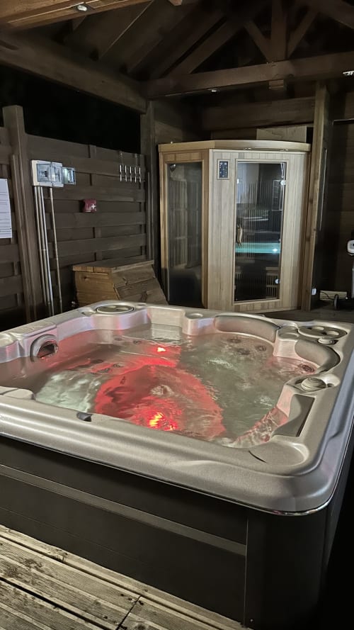 Luxueux bain à remous aux lumières de chromothérapie rouge dans l'espace spa de la maison d'hôtes Kaz A Bibi, Sainte-Rose