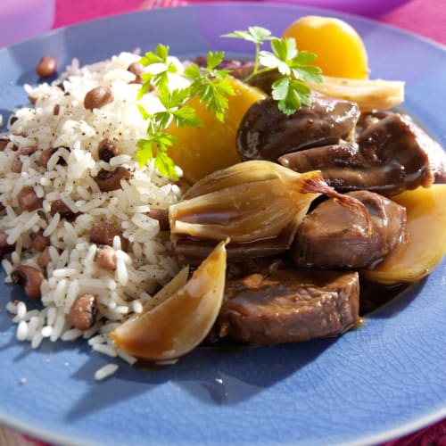 Assiette du restaurant Kaz A Bibi avec viande braisée, riz aux haricots, quartiers de citron et persil à Sainte-Rose, Guadeloupe