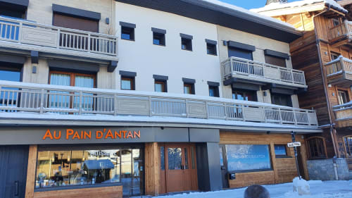 Façade de la boulangerie Au Pain d'Antan à la Résidence Le Pacha, hôtel de luxe à Courchevel, rue enneigée